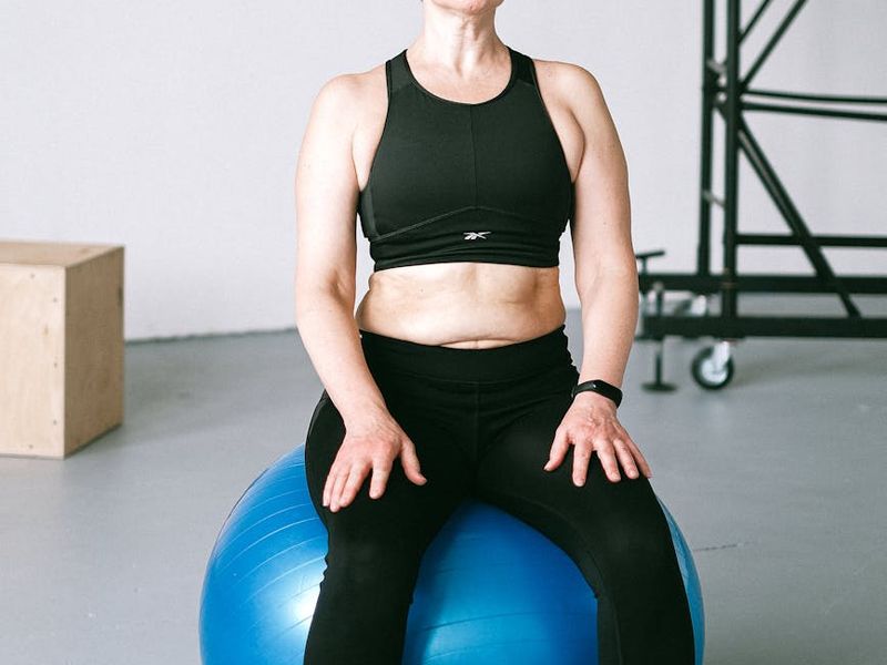 Athletic man performing core stability exercises in gym.
